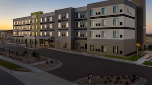 A multi-story hotel with a modern design, featuring a prominent 'HOME' sign, a well-maintained parking area, and a landscaped entrance. - Home2 Suites by Hilton Denver Central Park (Denver)