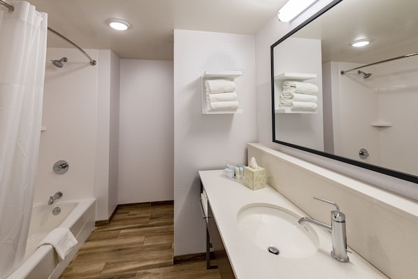 Un baño moderno con bañera, lavamanos y ducha.