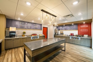 Cozinha moderna com ilha central, espaço para café e display de waffles.