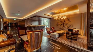 A modern lobby with a reception desk, seating area, and a large window offering a view.
