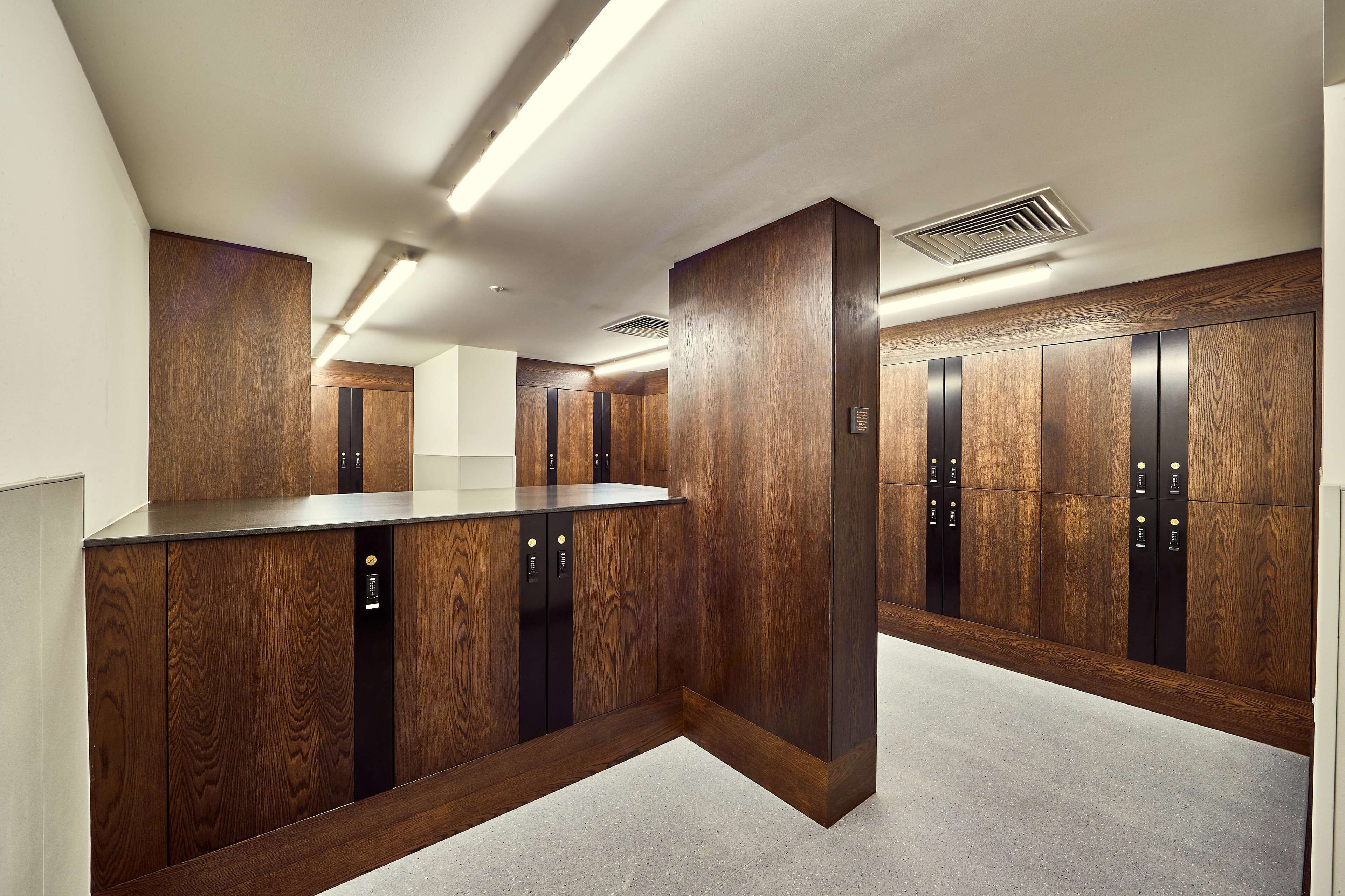 Een modern liftgedeelte met houten lambrisering en een centraal bedieningspaneel.