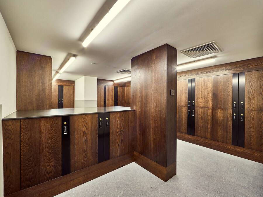Un'area ascensore moderna con rivestimenti in legno e un pannello di controllo centrale.