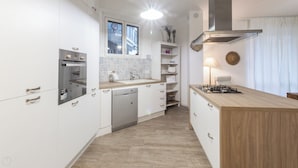 A modern kitchen with white cabinetry, a dishwasher, a built-in oven, a stove, and a window above the sink. - Italianway - Savona 26 B (Milan)