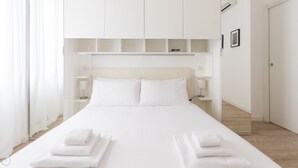A neatly made bed with white linens and towels, a white headboard, and bedside lamps. - Italianway - Corso Genova 27 A (Milan)