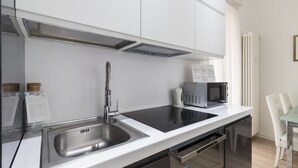 A modern kitchen with a stainless steel sink, a built-in stovetop, and a microwave. - Italianway - Corso Genova 27 A (Milan)