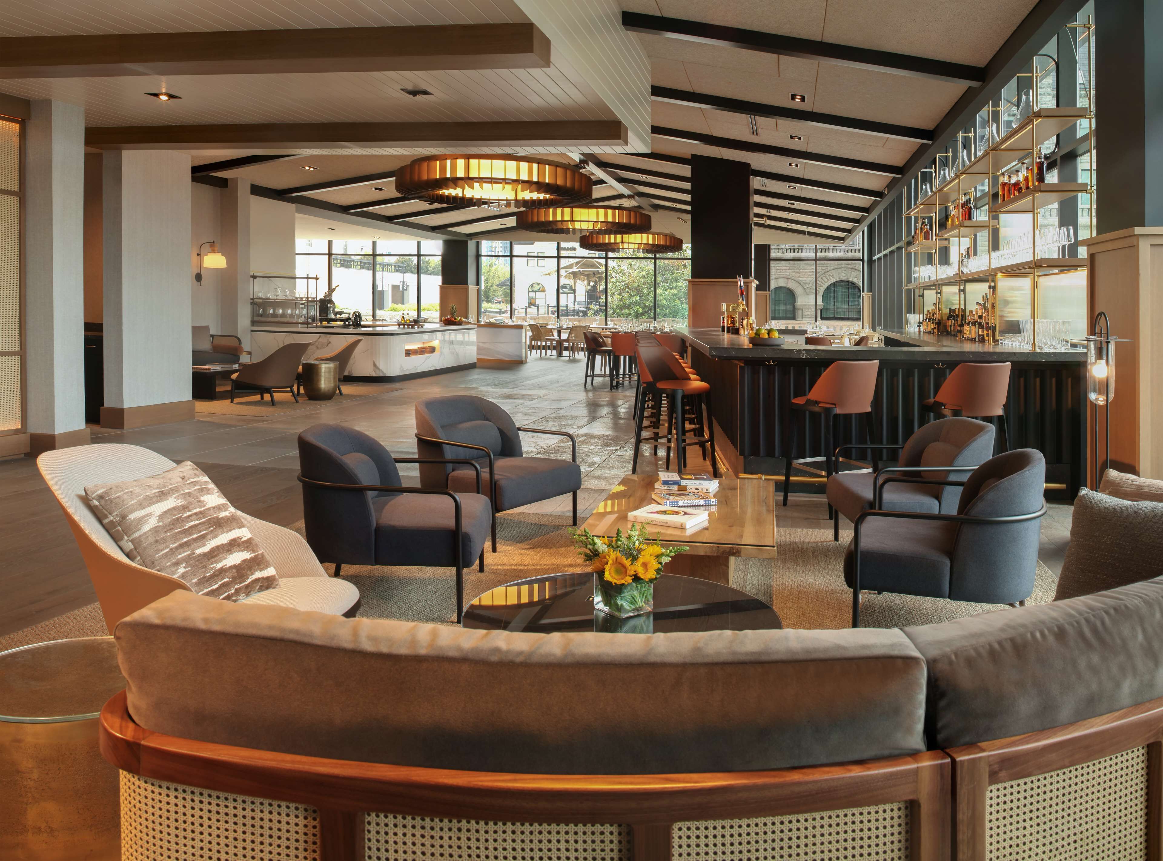 A spacious lobby with a bar area, comfortable seating, and large windows providing natural light.