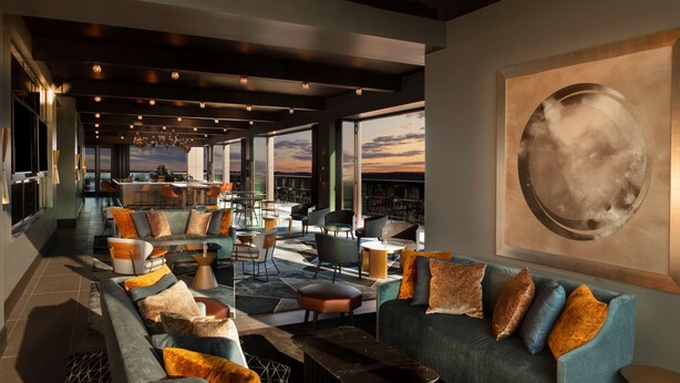 Un espace de détente moderne comprenant un canapé, des fauteuils et un bar.