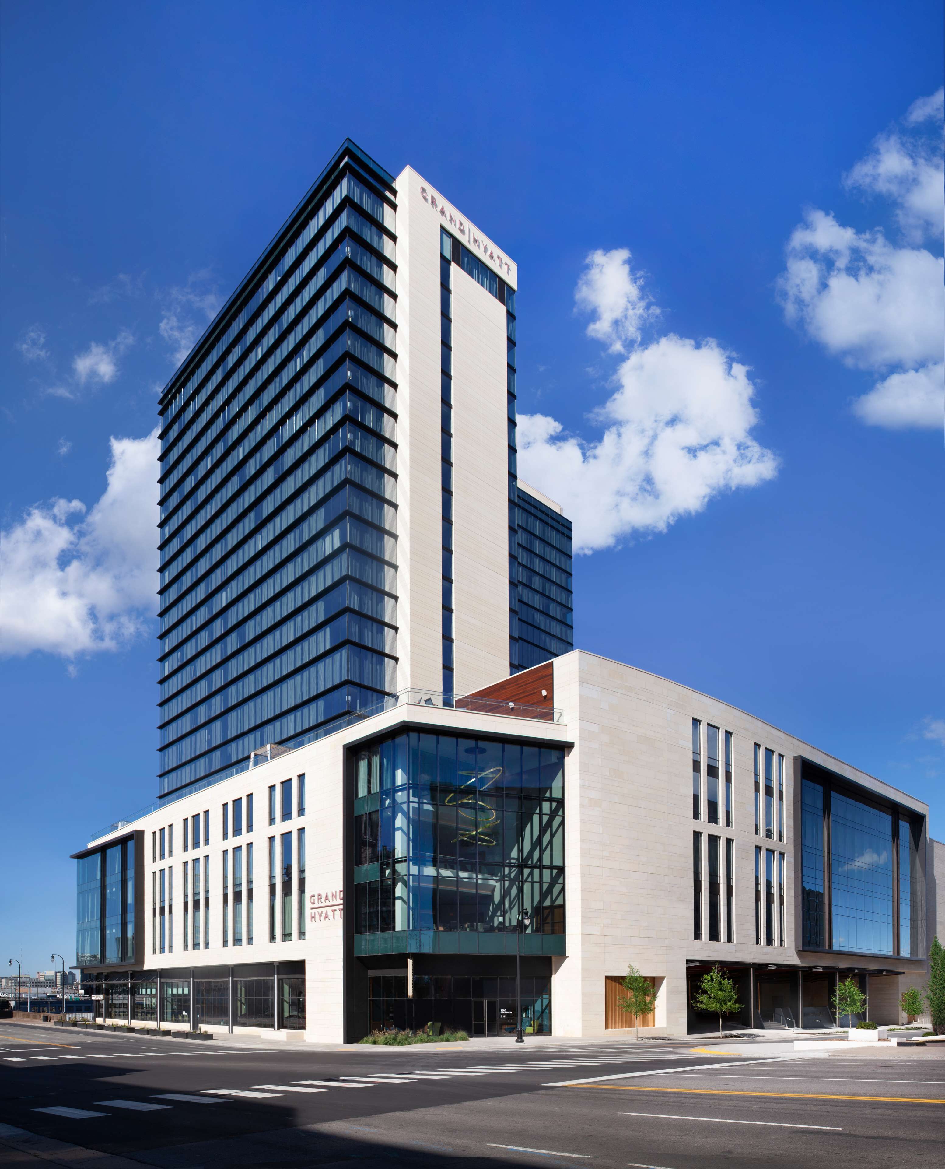 A modern hotel with a tall, rectangular building and a shorter annex.