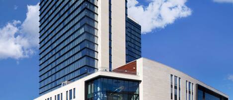 A modern hotel with a tall, rectangular building and a shorter annex.