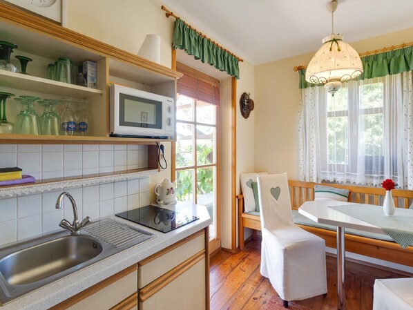 Enjoy meals in this well-equipped kitchen and dining area with a stainless steel sink, microwave, and ample kitchenware.