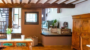 Une cuisine rustique avec une table en bois, une plante en pot et un buffet.
