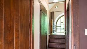 Un escalier en bois mène à une pièce dotée d’une fenêtre et d’une porte.