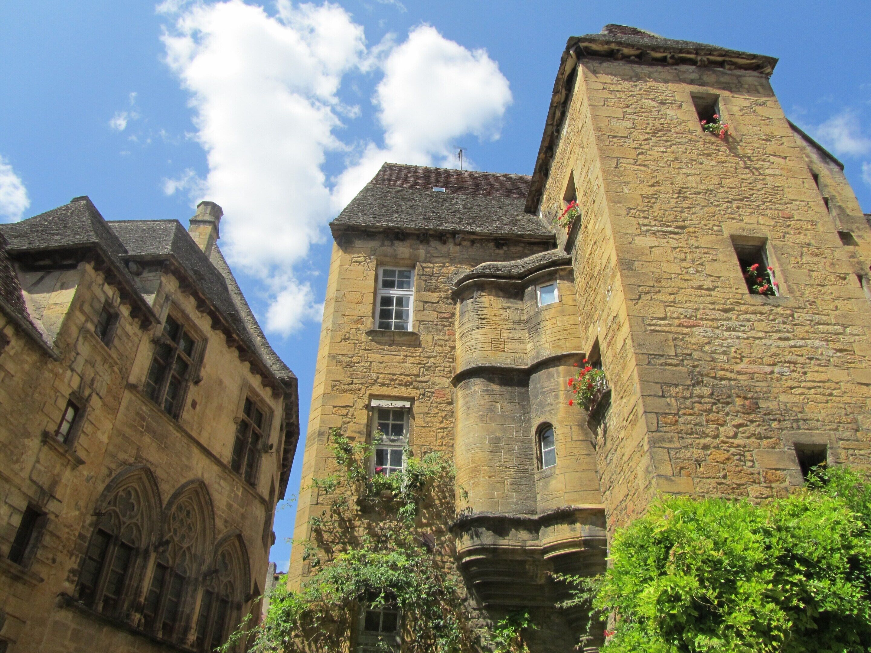 A historic stone building with multiple windows and a turret.
