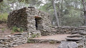 A stone structure with a doorway, surrounded by trees and a forested area. - Modern Villa in Camplong With Private Pool (Felines-Minervois)