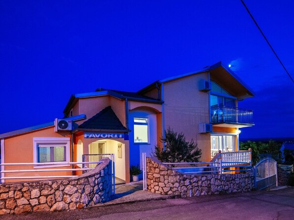 A two-story building with a stone facade, a balcony on the upper floor, and a sign that reads "FAVORIT". - Beautiful Holiday Home in Maslenica Near Beach" (Jasenice)