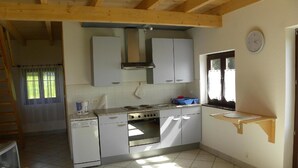Una cocina funcional con lavavajillas, estufa y ventana.