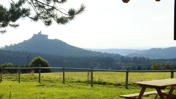 Una mesa de picnic y una vista de una colina con una estructura en la cima.