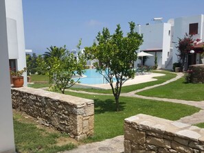 A courtyard with a swimming pool, stone walls, and small trees. - Splendid Holiday Home With Swimming Pool (Rethymno)