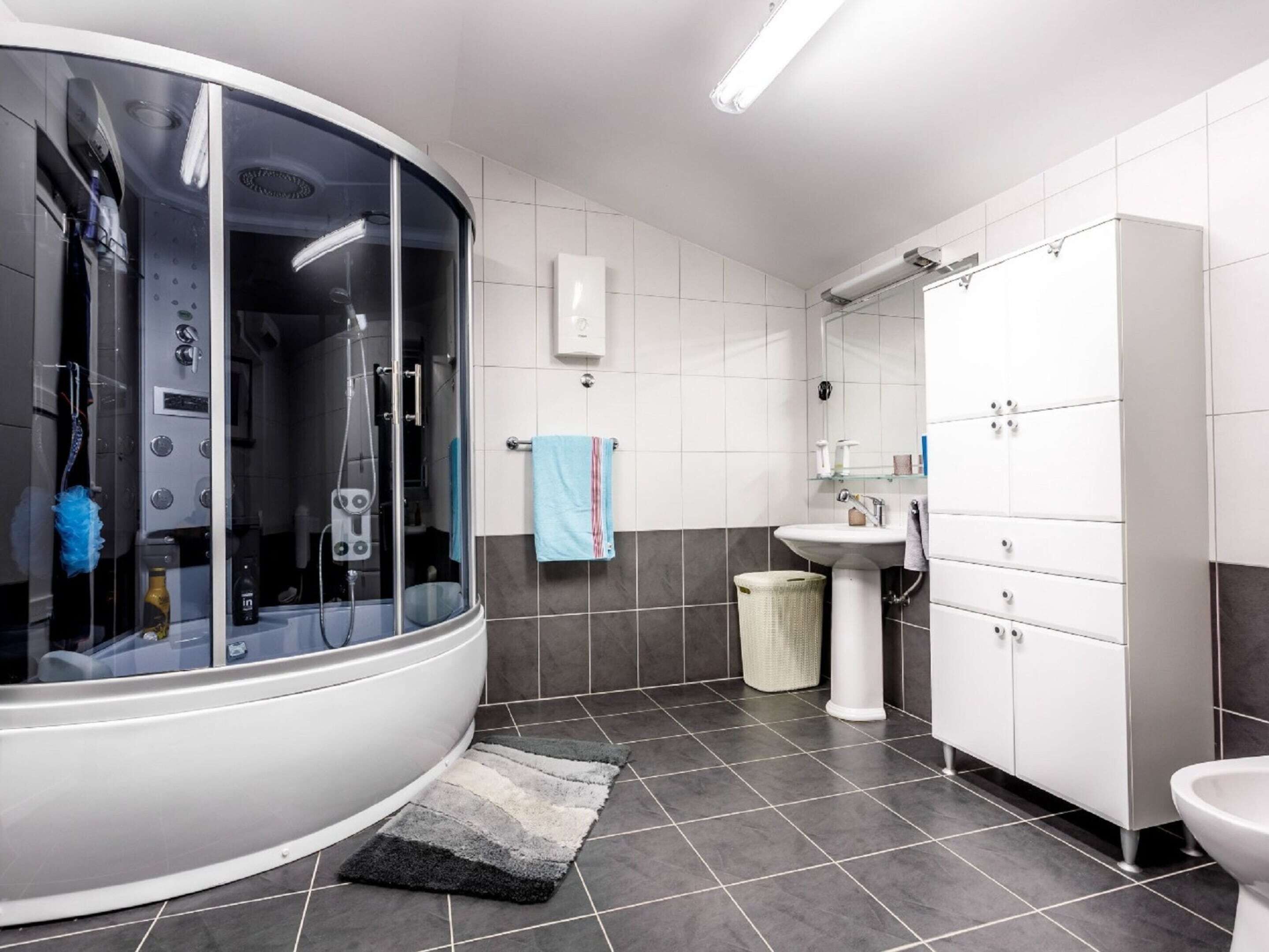 Ein modernes Badezimmer mit einer Duschkabine, einem Waschbecken und einer Toilette.