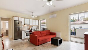 Un apartament modern amb cuina, saló i balcó.