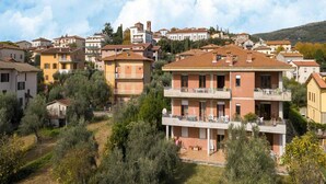 A residential area with multi-story buildings, some with balconies, surrounded by greenery and trees. - Apartment in Tuoro Near Lake Trasimeno (Tuoro sul Trasimeno)