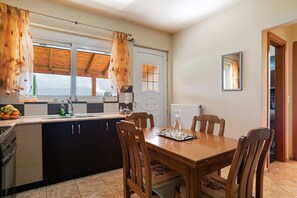 Enjoy meals in the spacious kitchen and dining area, featuring a large island, oven, and dining table for four.
