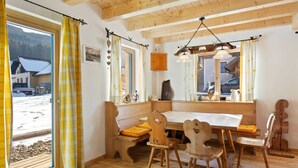 A wooden dining room with a bench, chairs, and a table.