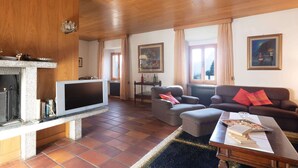 A living room with a fireplace, television, and seating area. - Castle in Clouds; A Holiday Home (Stenico)