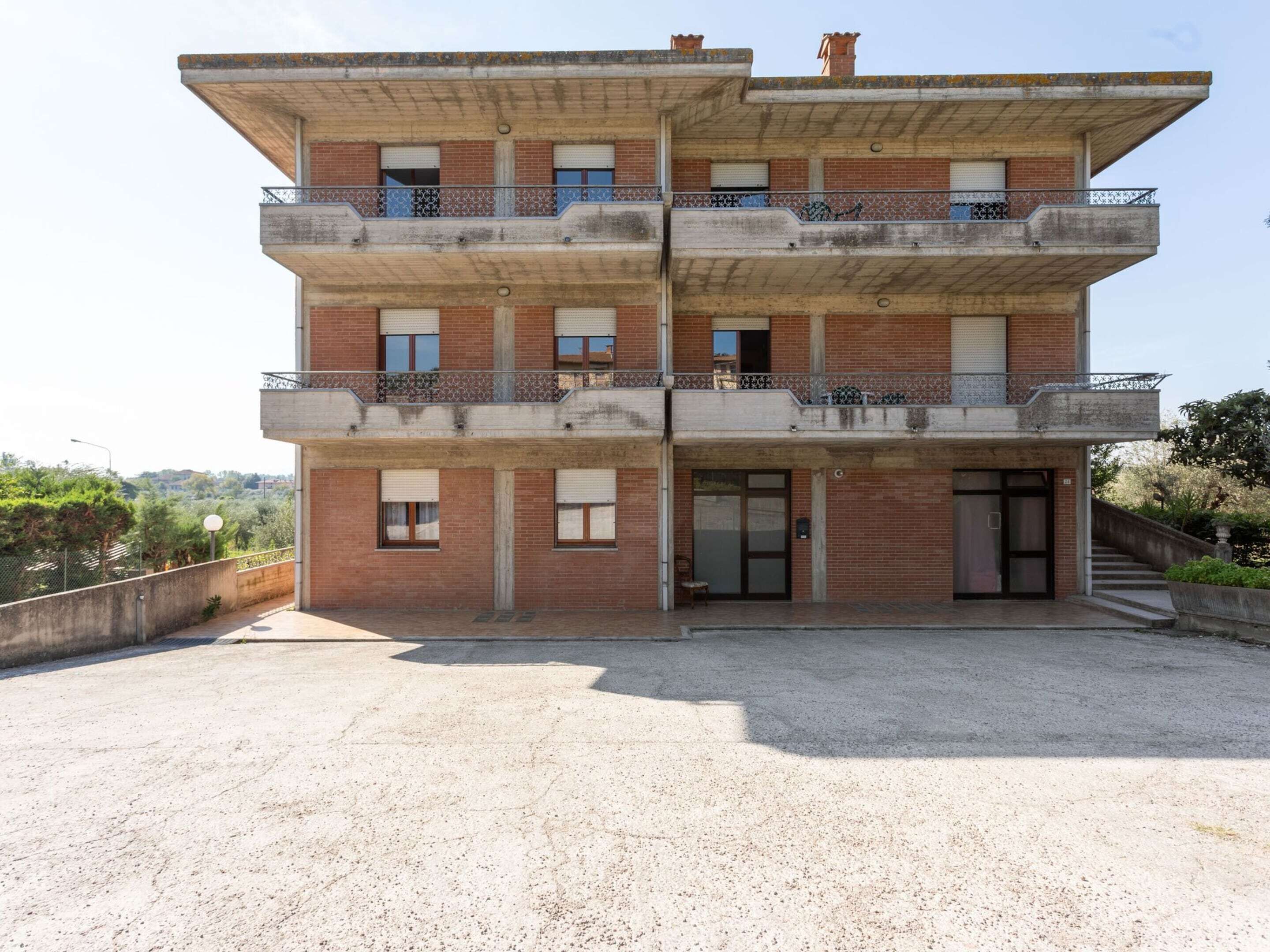 Un immeuble à plusieurs étages, doté de balcons, d’une entrée au niveau du sol et offrant une vue sur les environs.