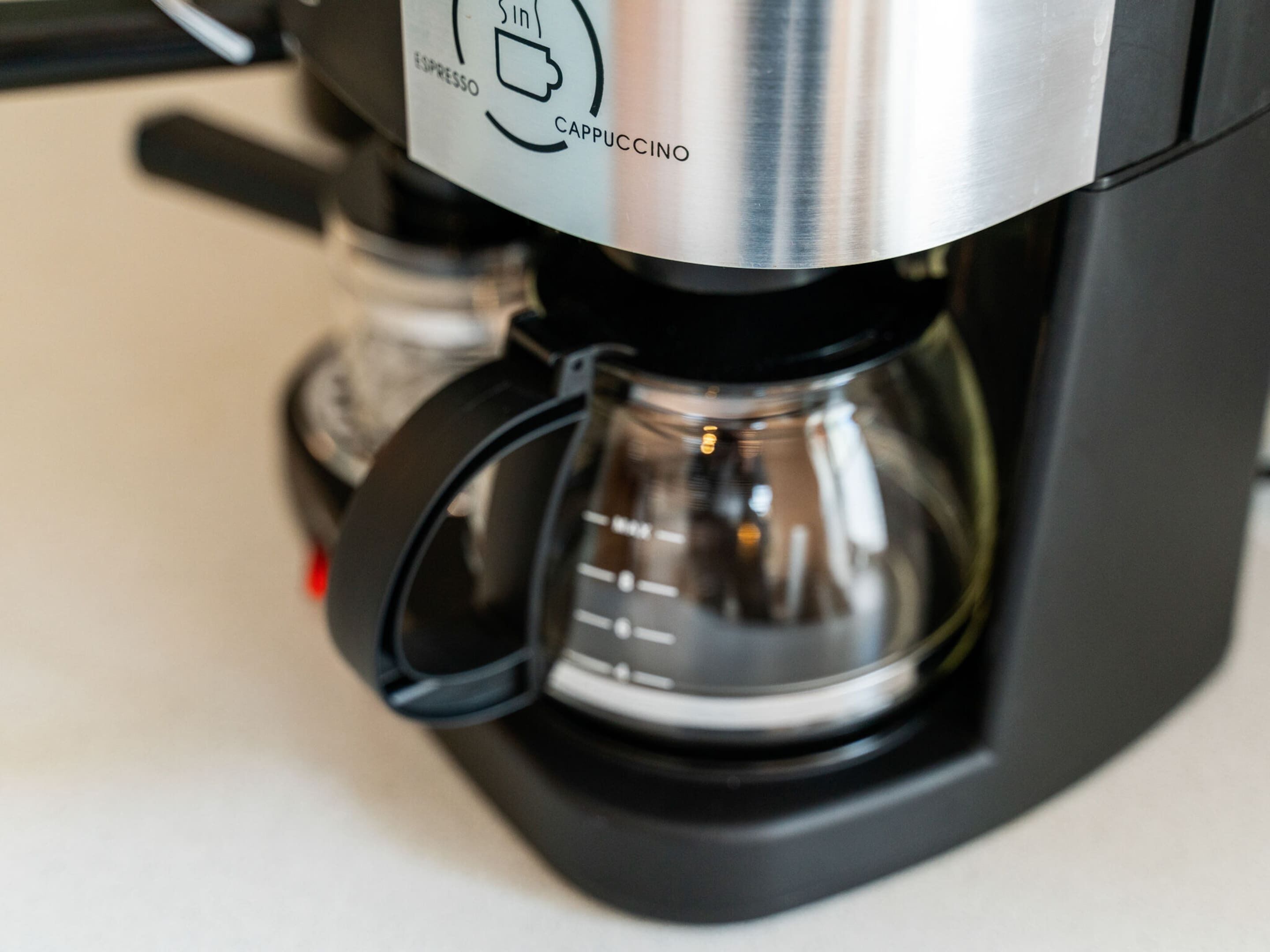 Une machine à café munie d’une étiquette indiquant qu’elle peut préparer des expressos et des cappuccinos.
