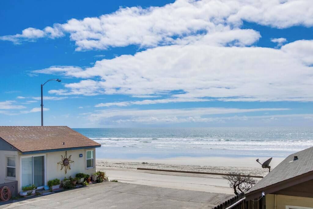 A beachfront property with a small building, a street lamp, and a clear view of the ocean.