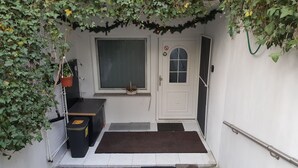 A small, enclosed porch with a white door, a window, and a small table. - '4er Müggelwaldzimmer' quiet + cozy apartment in Köpenick m. Garden area (Bezirk Treptow-Köpenick)