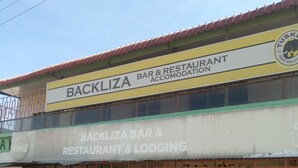 Um edifício com placas indicando Backliza Bar & Restaurant & Lodging.
