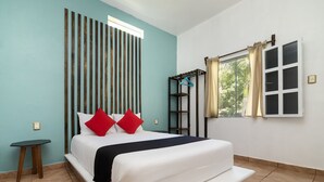 A neatly arranged bedroom with a bed, a small table, and a window with curtains. - Villas el Paraíso, El Rollo (Tlaquiltenango)