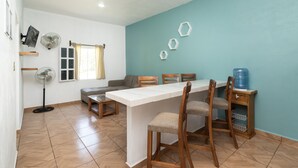 A dining area with a long table, four chairs, a bench, and a water dispenser. - Villas el Paraíso, El Rollo (Tlaquiltenango)