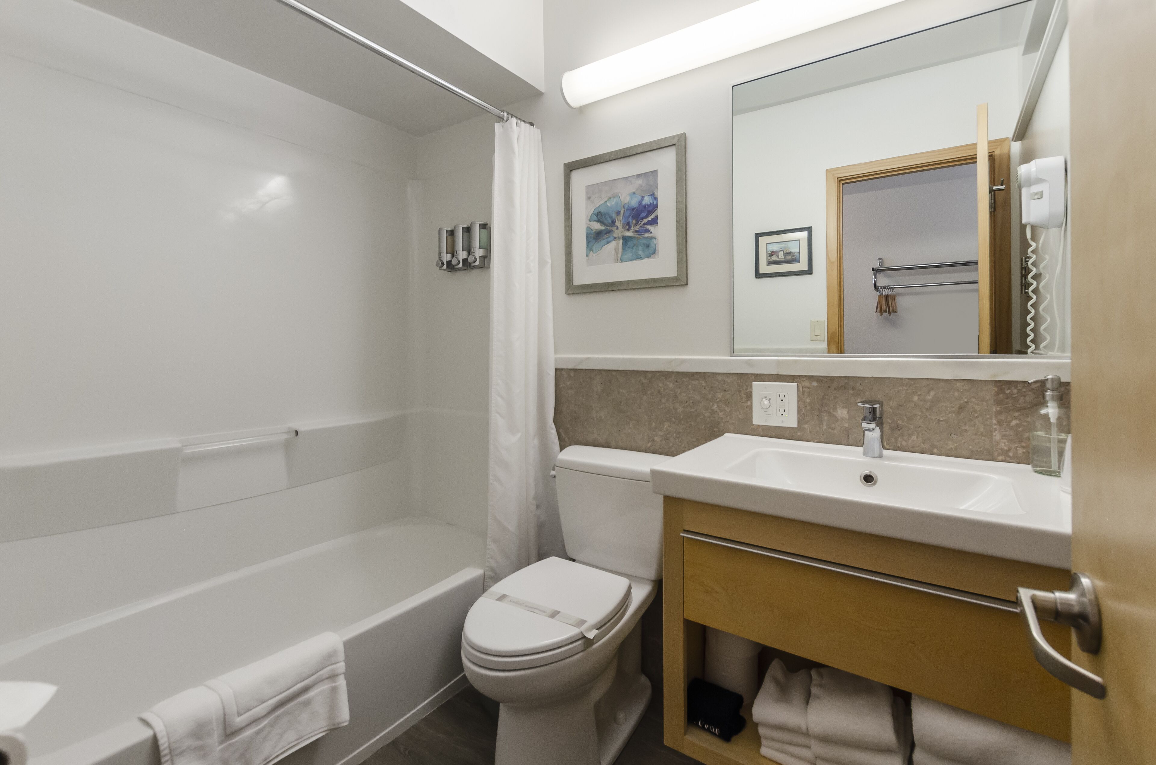 A modern bathroom with a bathtub, toilet, and sink.