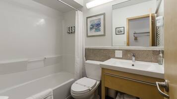 A modern bathroom with a bathtub, toilet, and sink.