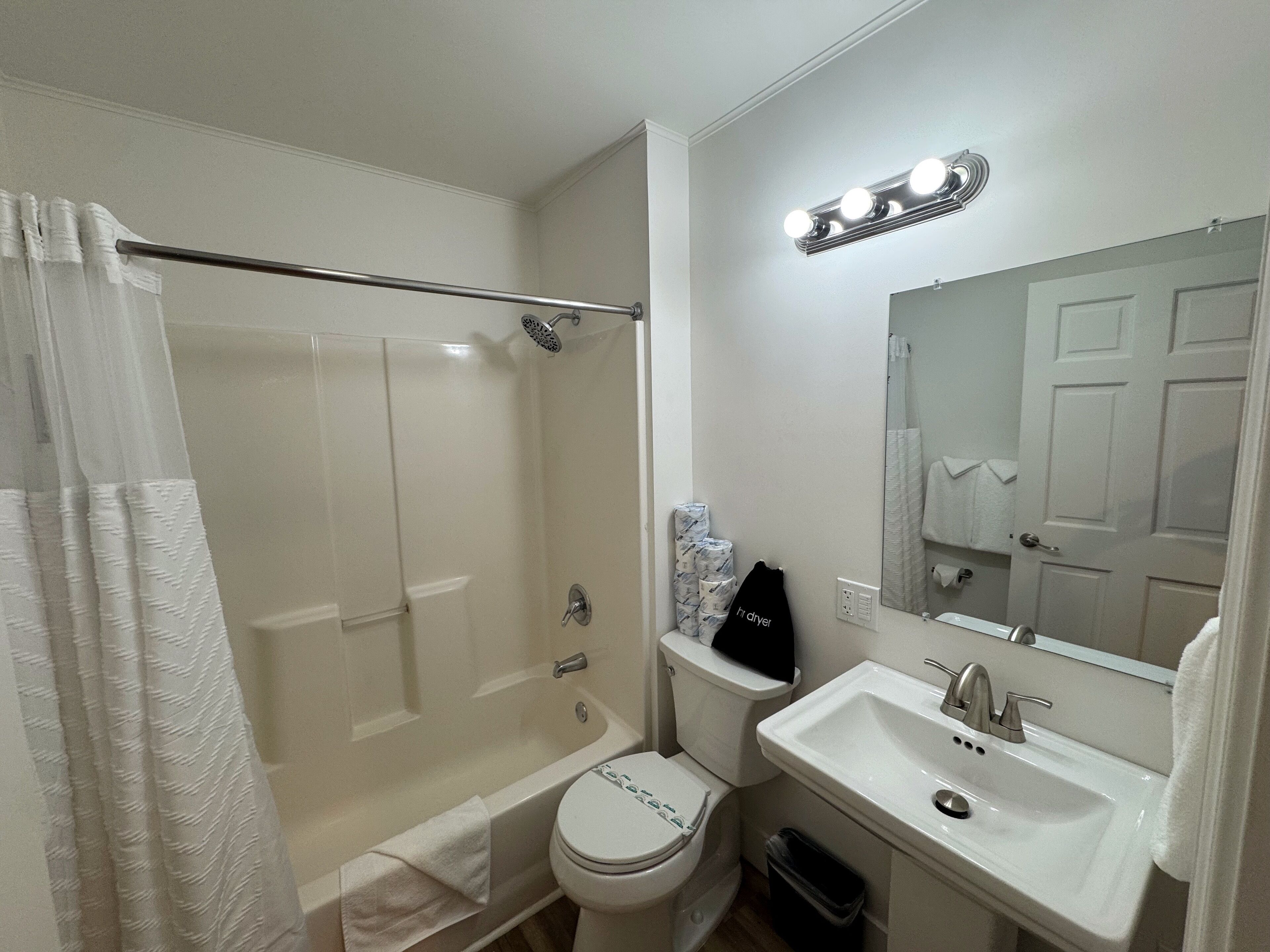 A modern bathroom with a walk-in shower, toilet, and sink.