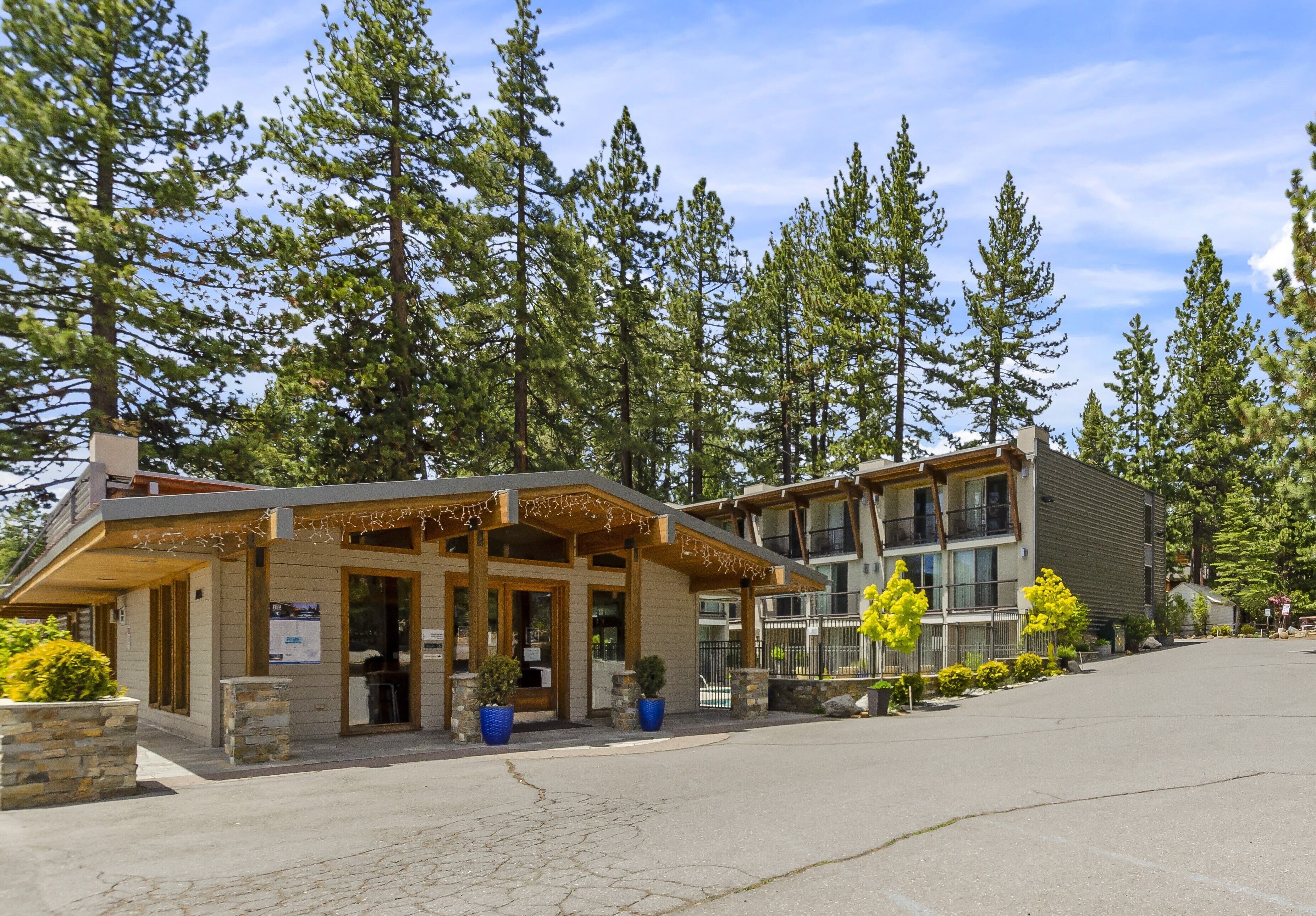 A lodge with a covered entrance, outdoor seating, and a parking area.