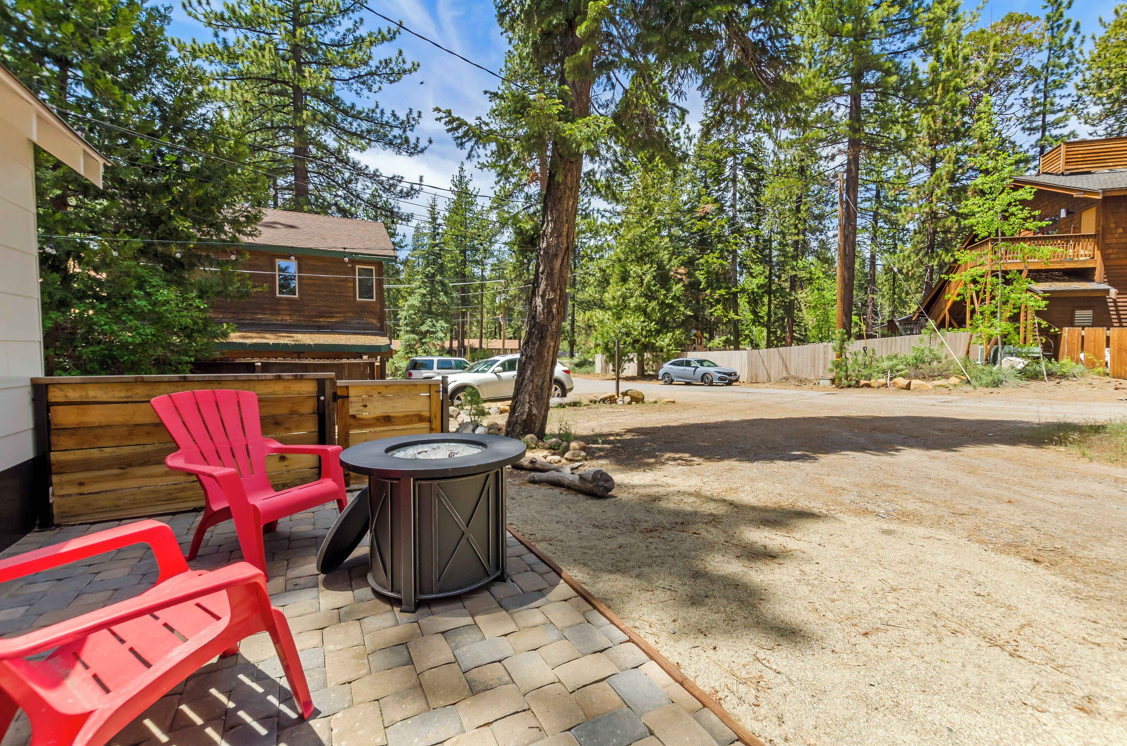 A patio area with red chairs, a table, and a hot tub.