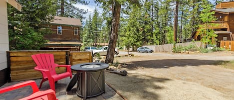 A patio area with red chairs, a table, and a hot tub.