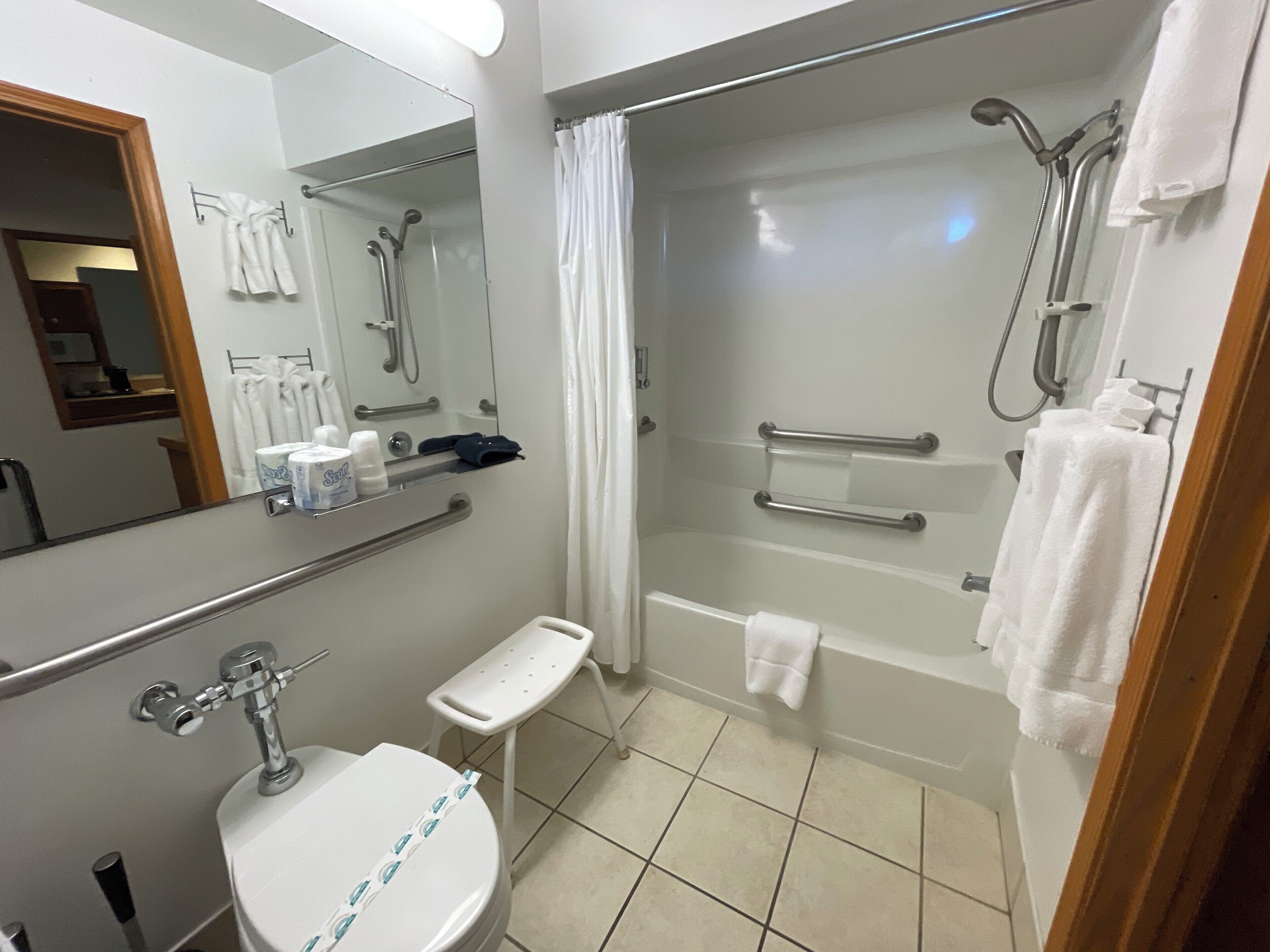 A modern bathroom with a shower, toilet, and sink.