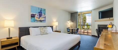 Habitación de hotel con una cama grande, un escritorio, una silla, un televisor y un cuadro en la pared.