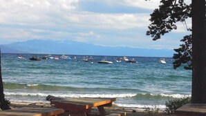 A beach with picnic tables and boats in the water. - Firelite Lodge (Kings Beach)