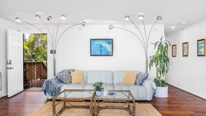 Una sala de estar moderna con un sofá, una mesa de centro e iluminación colgante.