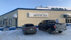 En byggnad med en skylt som visar texten "Sheridan Lawrence Motor Inn".