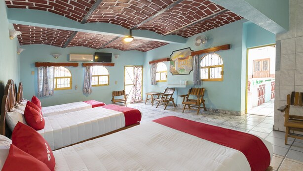 A room with two beds, a wooden desk, and a chair. - Hotel Posada Agua Escondida (Cihuatlan)