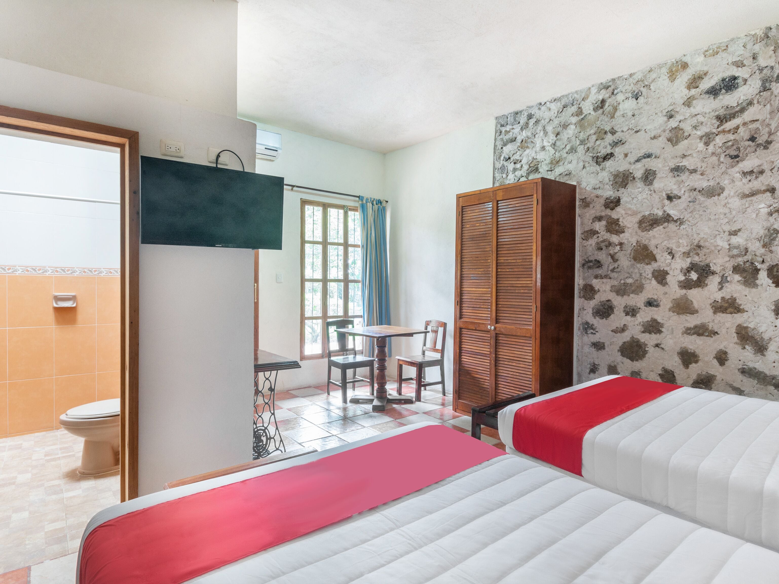 A hotel room with a bed, a wardrobe, a desk, and a bathroom.