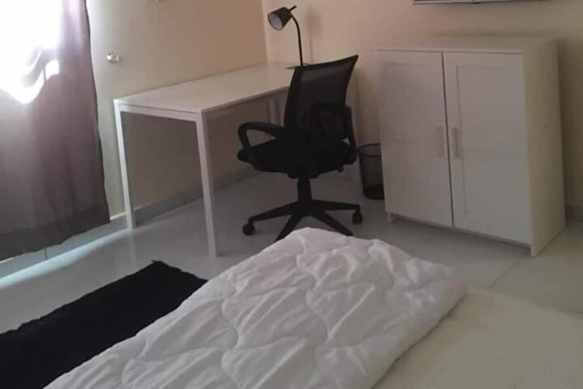 Une chambre d’hôtel comprenant un lit, un bureau, une chaise, une télévision et une armoire.