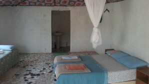 A room with two beds, a patterned ceiling, and a hanging white canopy. - Camping Sitaba Lodge (Janjanbureh)